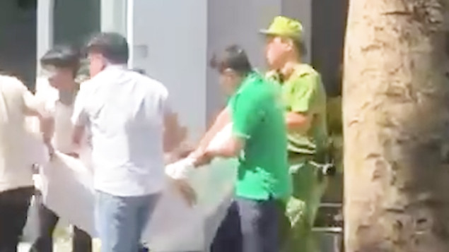 Lực lượng chức năng đưa bà Lê Thị T.Q. đi bệnh viện cấp cứu. Ảnh chụp lại clip.