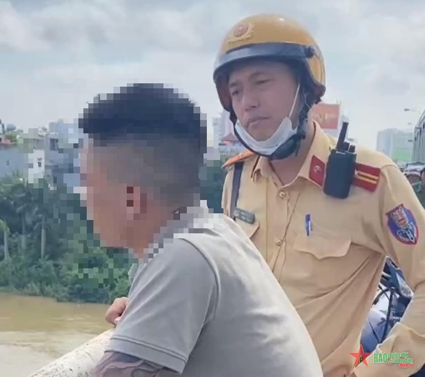 Cảnh sát giao thông khuyên can thanh niên N.Q.L từ bỏ ý định nhảy cầu tự tử. Ảnh: Công an cung cấp