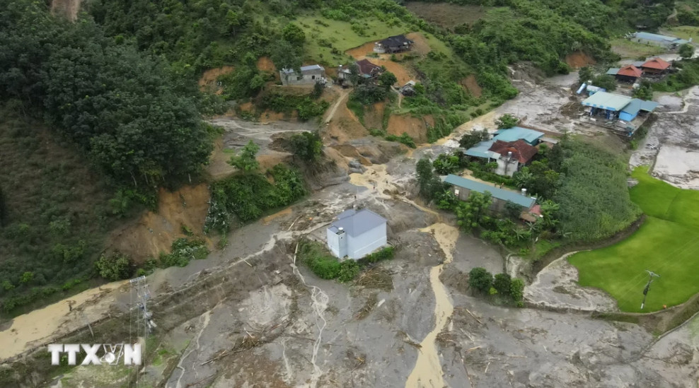 Lũ quét cuốn qua nhiều căn nhà. (Ảnh: Xuân Tư/TTXVN)