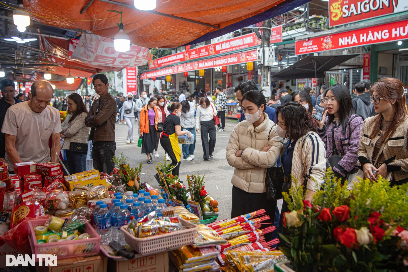 Quầy hàng bán đồ lễ như vàng hương, bánh kẹo, hoa quả... cũng đông đúc khách mua hàng.