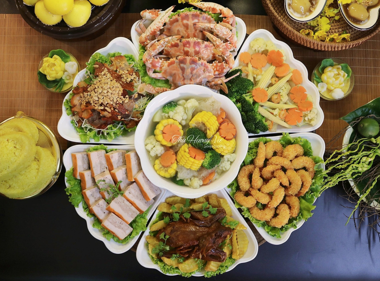 Mâm cỗ cúng với gà luộc, xôi, ghẹ hấp, bóng xào, tôm chiên, chim quay ngũ vị, chả quế, khoai chiên, bánh bao kim sa...