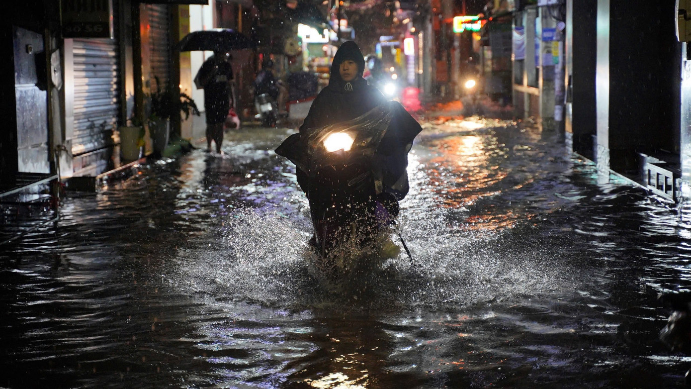 Nhiều xe máy liều mình vượt qua "biển nước" trên đường Trần Bính Nhiều xe máy liều mình vượt qua "biển nước" trên đường Trần Bính