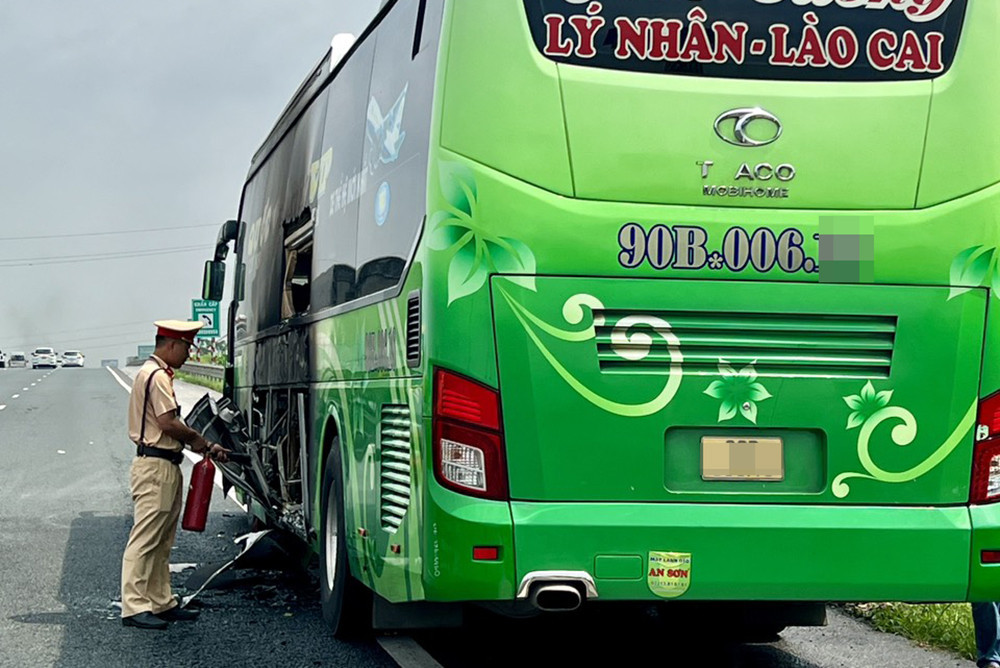 Lực lượng CSGT kịp thời dập tắt đám cháy ô tô khách. Ảnh: CACC