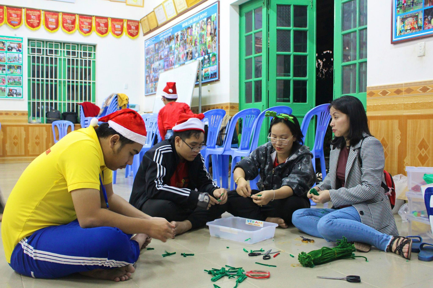 Ở một góc nhỏ, các tình nguyện viên miệt mài cắt, dán, chuẩn bị vật liệu để trang trí cây thông.