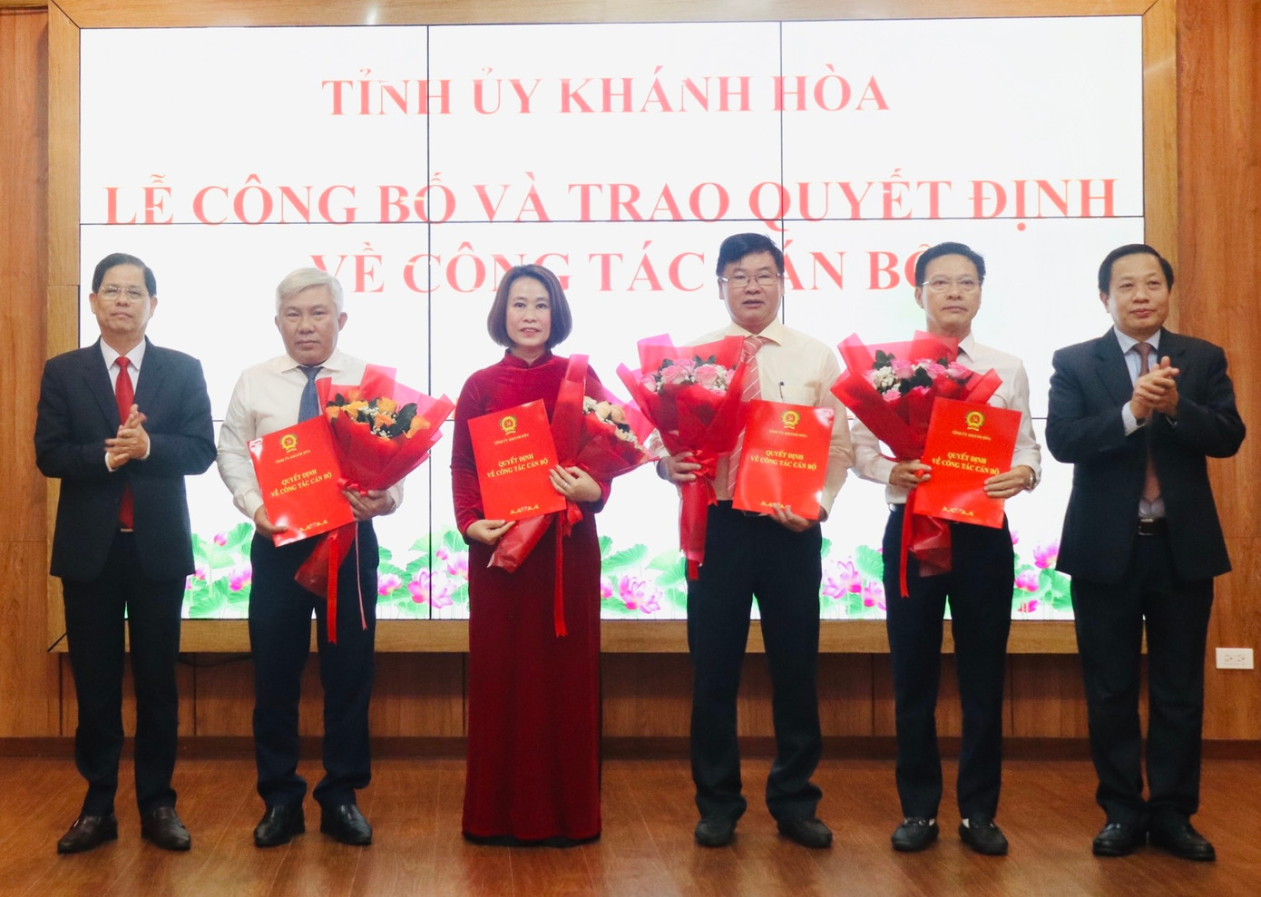 Chủ tịch UBND tỉnh Khánh Hòa Nguyễn Tấn Tuân (bìa trái) và Phó Bí thư Tỉnh ủy Hà Quốc Trị (bìa phải) trao quyết định cho các cán bộ khối chính quyền và HĐND tỉnh. Ảnh: X.T.