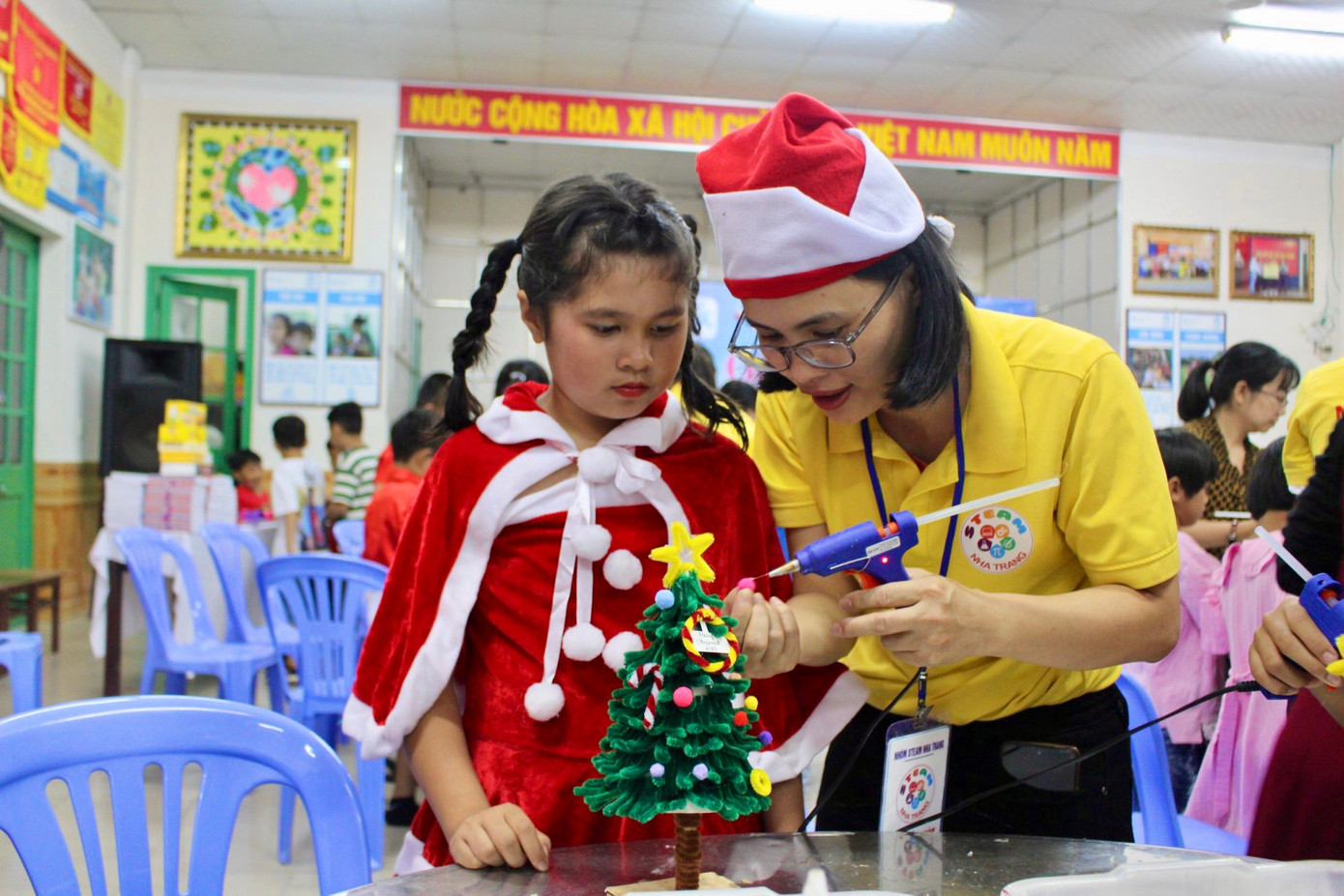 Chị Trần Thị Liên (áo vàng, tình nguyện viên) chia sẻ: “Những vật dụng làm cây thông Noel được các thành viên thực hiện hoàn toàn thủ công nhằm tiết kiệm chi phí và đảm bảo độ đẹp mắt như mong muốn. Công tác chuẩn bị kéo dài suốt một tuần nhưng ai cũng vui và háo hức”.