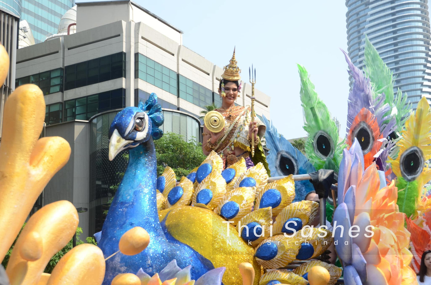 Đương kim Hoa hậu Hoàn vũ 2023 Sheynnis Palacios cũng tham dự sự kiện diễu hành trên đường phố. Cô mặc trang phục dân tộc Thái Lan với những phụ kiện lộng lẫy, đẹp mắt. Người đẹp đang có chuyến công tác tại các nước Đông Nam Á. Cuối tháng 4, cô đến Việt Nam.