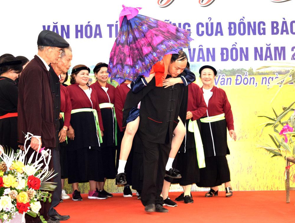 Lễ hội cũng phục dựng đám cưới truyền thống Sán Dìu, khi nhà trai mang lễ vật đến, nhà gái thách đố bằng làn điệu Sọong cô. Nhà trai hát đối lại được, nhà gái cho rước dâu. Chú rể cõng cô dâu về nhà mình. Ảnh Công Thành.