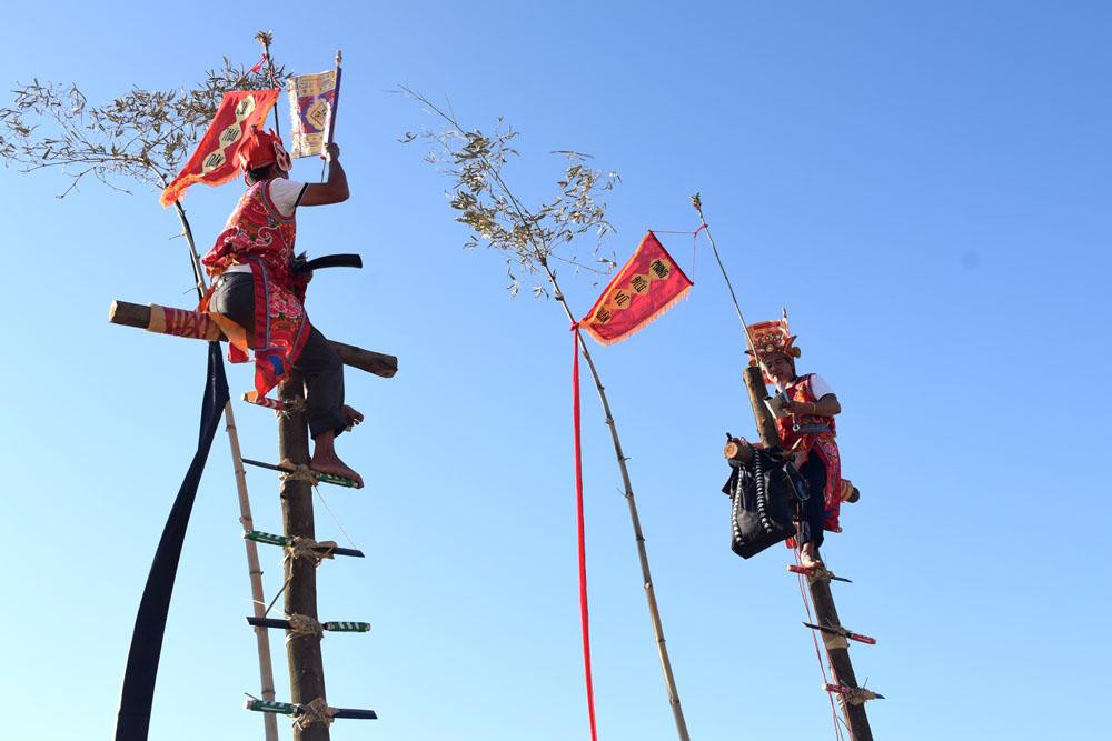 Khi leo qua 12 lưỡi dao, các thầy mo sẽ tiến hành nghi lễ cầu trời cho quanh năm mưa thuận gió hòa, mùa màng tốt tươi. Mặc dù đi chân đất để leo dao nhưng các thầy mo vẫn không hề hấn gì. Ảnh Công Thành.