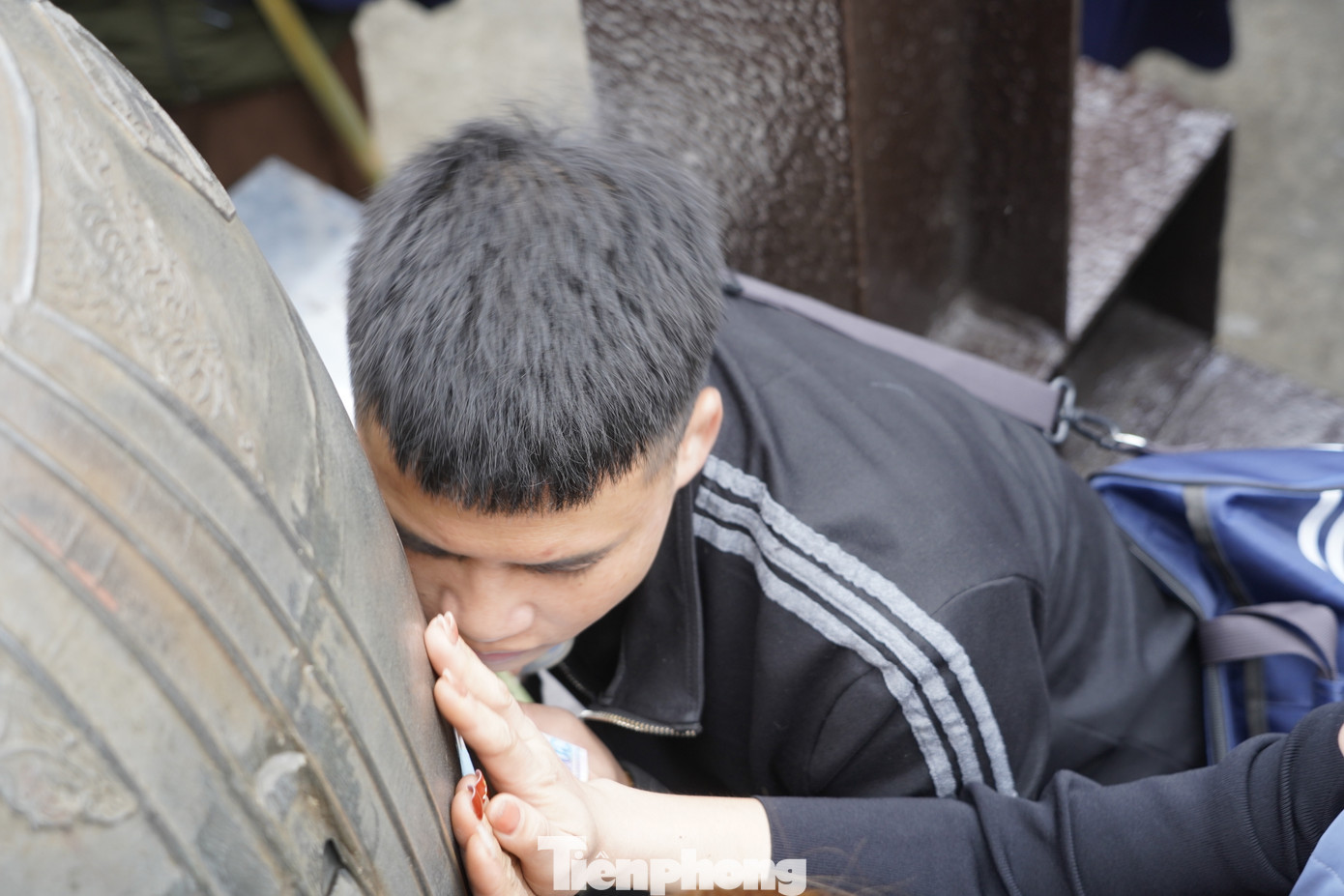 Nhiều người còn áp cả má vào chuông để cầu tài lộc trong năm mới. Ảnh: HOÀNG DƯƠNG.