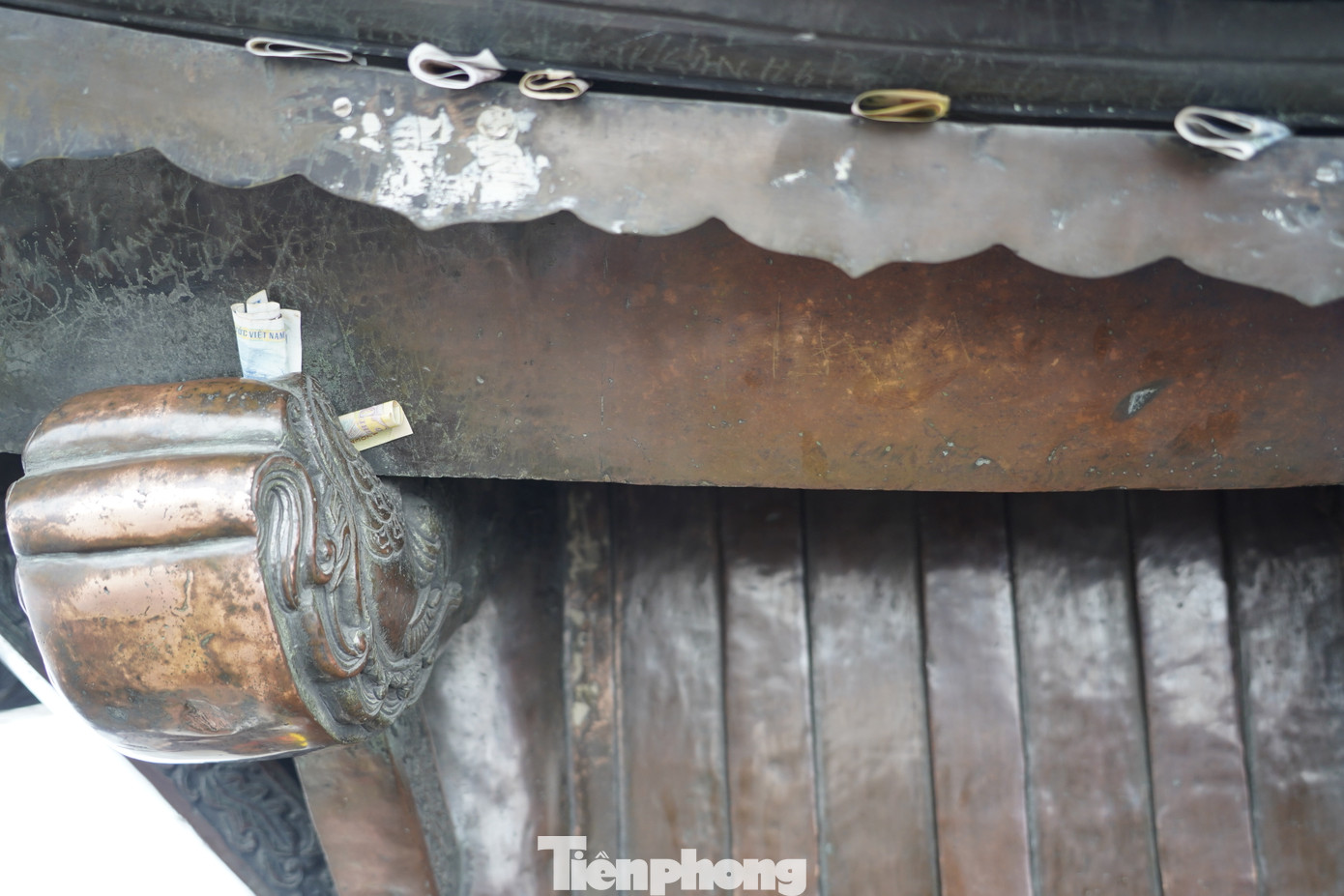 Người dân còn dùng tiền găm vào mái chùa để cầu may. Trước đây tình trạng ném tiền lẻ lên chùa đã được lực lượng chức năng chấn chỉnh. Ảnh: HOÀNG DƯƠNG.