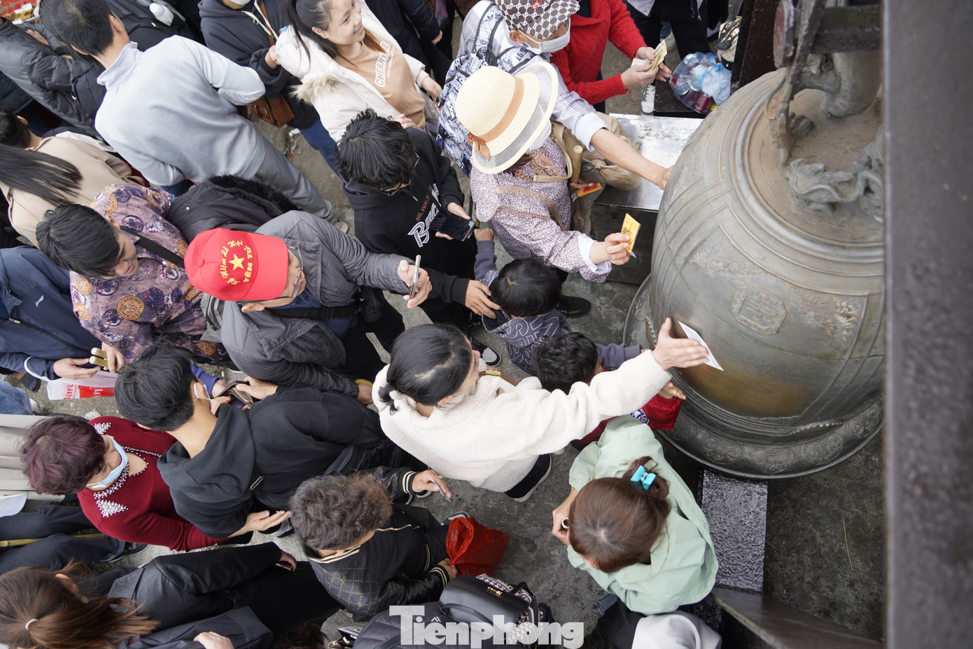Hàng nghìn người lên chùa Đồng đều dùng tiền để chà vào chuông, khánh và tường của chùa để cầu may. Ảnh: HOÀNG DƯƠNG.