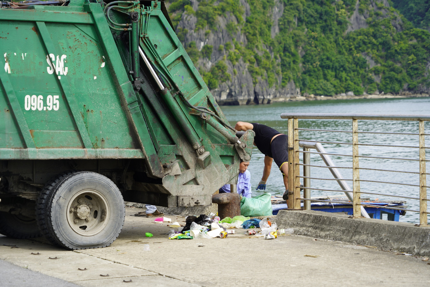 Rác thải vung vãi khắp nơi trong quá trình chuyền vận chuyển bằng tay từ tàu lên bờ và từ bờ lên xe chở rác.