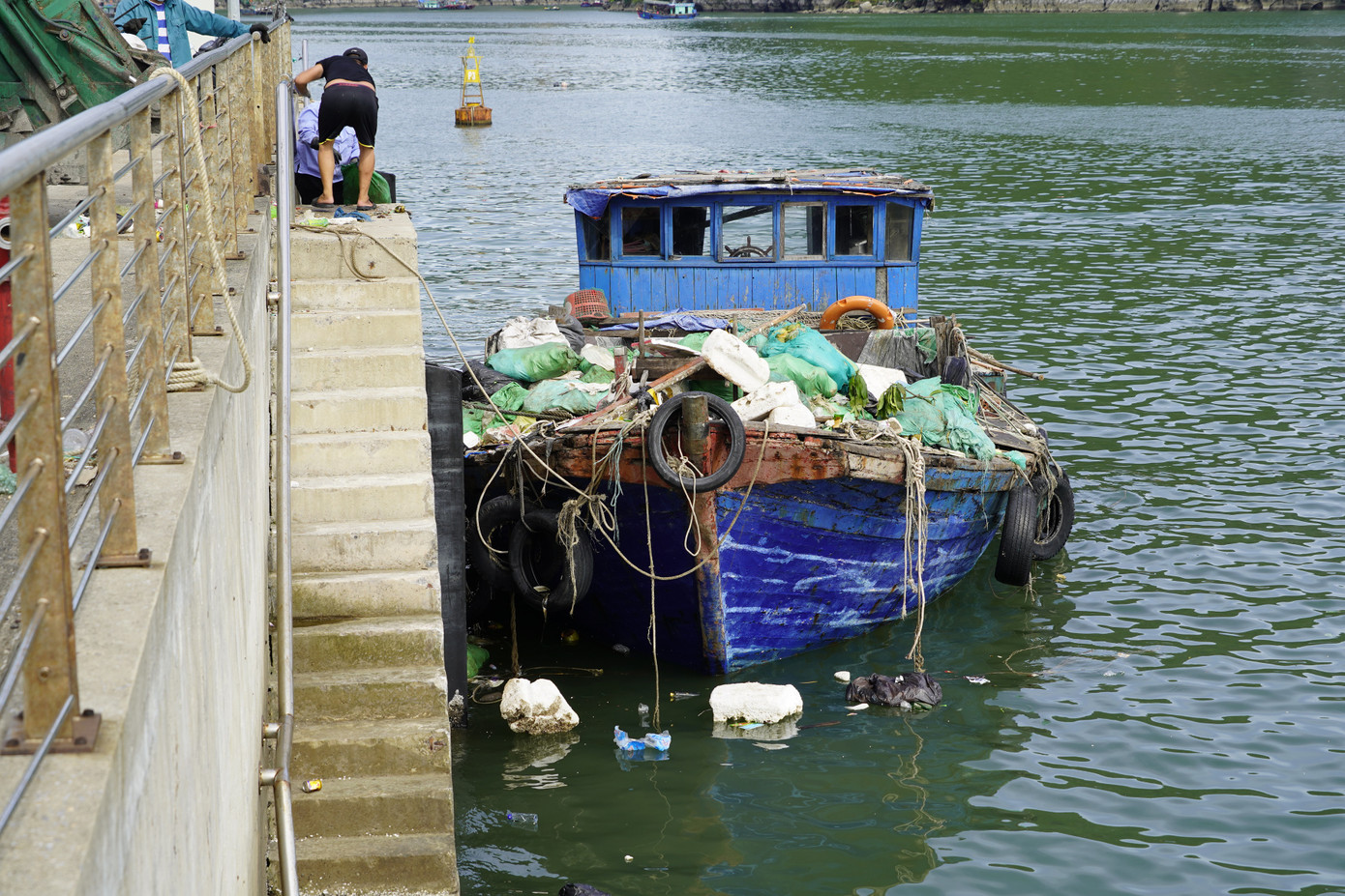 Mặc dù được coi là khâu cực kỳ quan trọng trong việc bảo vệ và phát huy thế mạnh của di sản nhưng công tác vệ sinh môi trường trên vịnh Hạ Long vẫn còn nhiều bất cập. Trong ảnh là thuyền vớt rác của công nhân môi trường vịnh. Chiếc thuyền rách nát, cũ kỹ không có khoang chứa rác cũng như các bao đựng rác chuyên dụng. Trong lúc vận chuyển rác lên bờ, một khối lượng lớn rác thải lại rơi vãi xuống Vịnh.