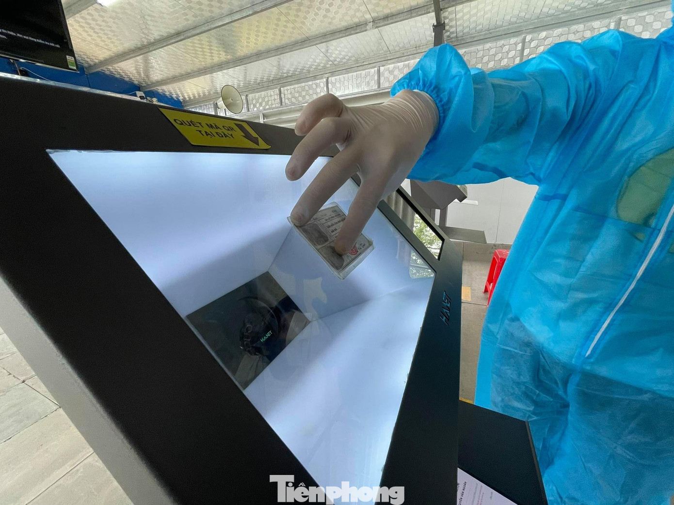 Cán bộ hỗ trợ việc quét thông tin cá nhân của người dân tại hệ thống máy kiểm soát tự động. Cán bộ hỗ trợ việc quét thông tin cá nhân của người dân tại hệ thống máy kiểm soát tự động.