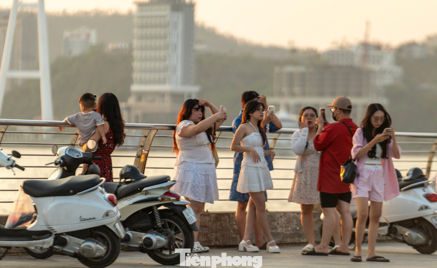 Du khách đến Hạ Long thường tập trung tại các địa điểm có không gian rộng như khu vực chân cầu Bãi Cháy, khu bãi biển Bãi Cháy và trước đảo Rều để nhìn cảnh mặt trời lặn ở cuối chân trời.