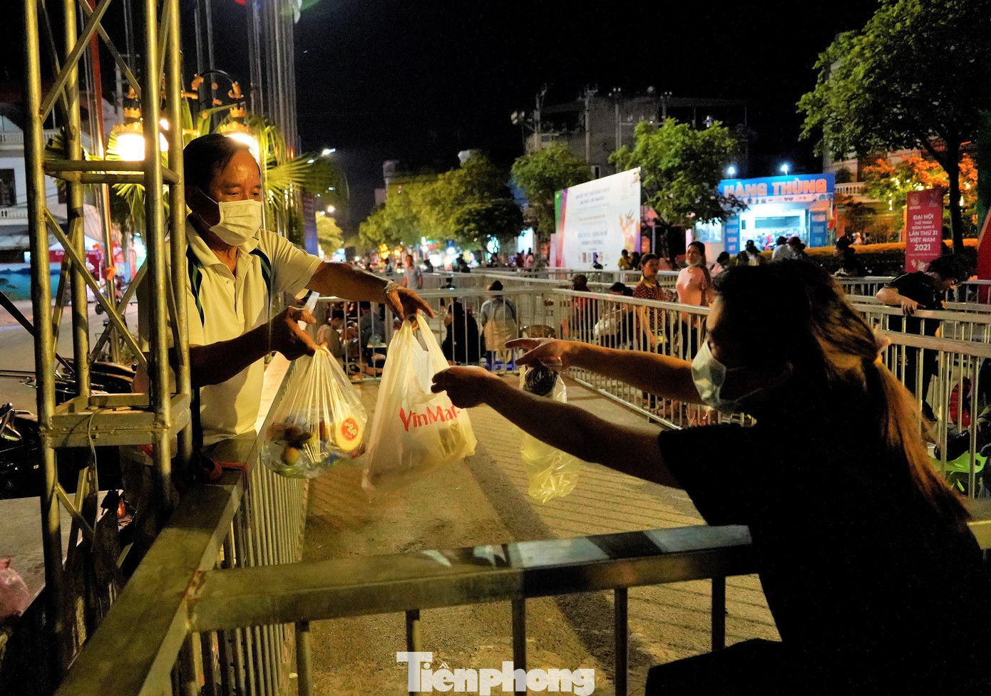 Chồng tiếp tế thức ăn, nước uống cho vợ để bổ sung thêm năng lượng tiếp tục xếp hàng xuyên đêm.