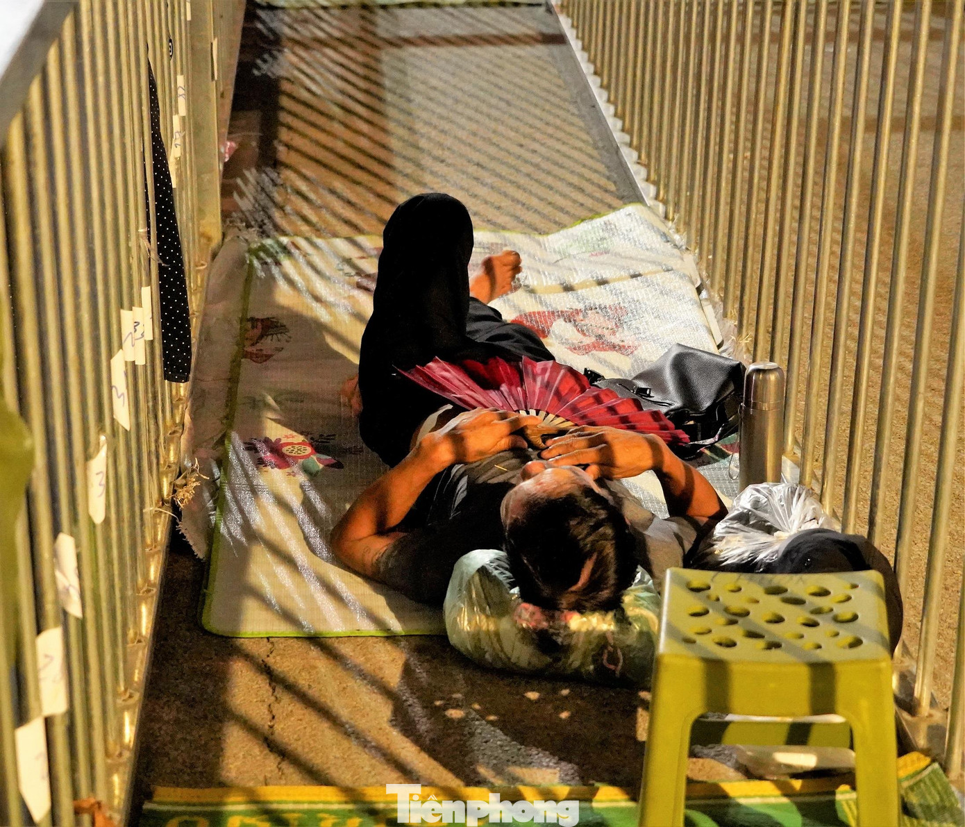 Nhiều người mang chăn chiếu để ngủ ở vị trí xếp hàng, bất chấp hơi nóng phả ra từ nền bê tông.