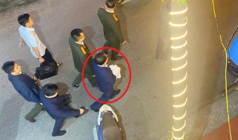 Ông Nguyễn Đình Đương (người trong dấu khoanh đỏ) bị áp giải về cơ quan Công an vào tối 13/3/2023.