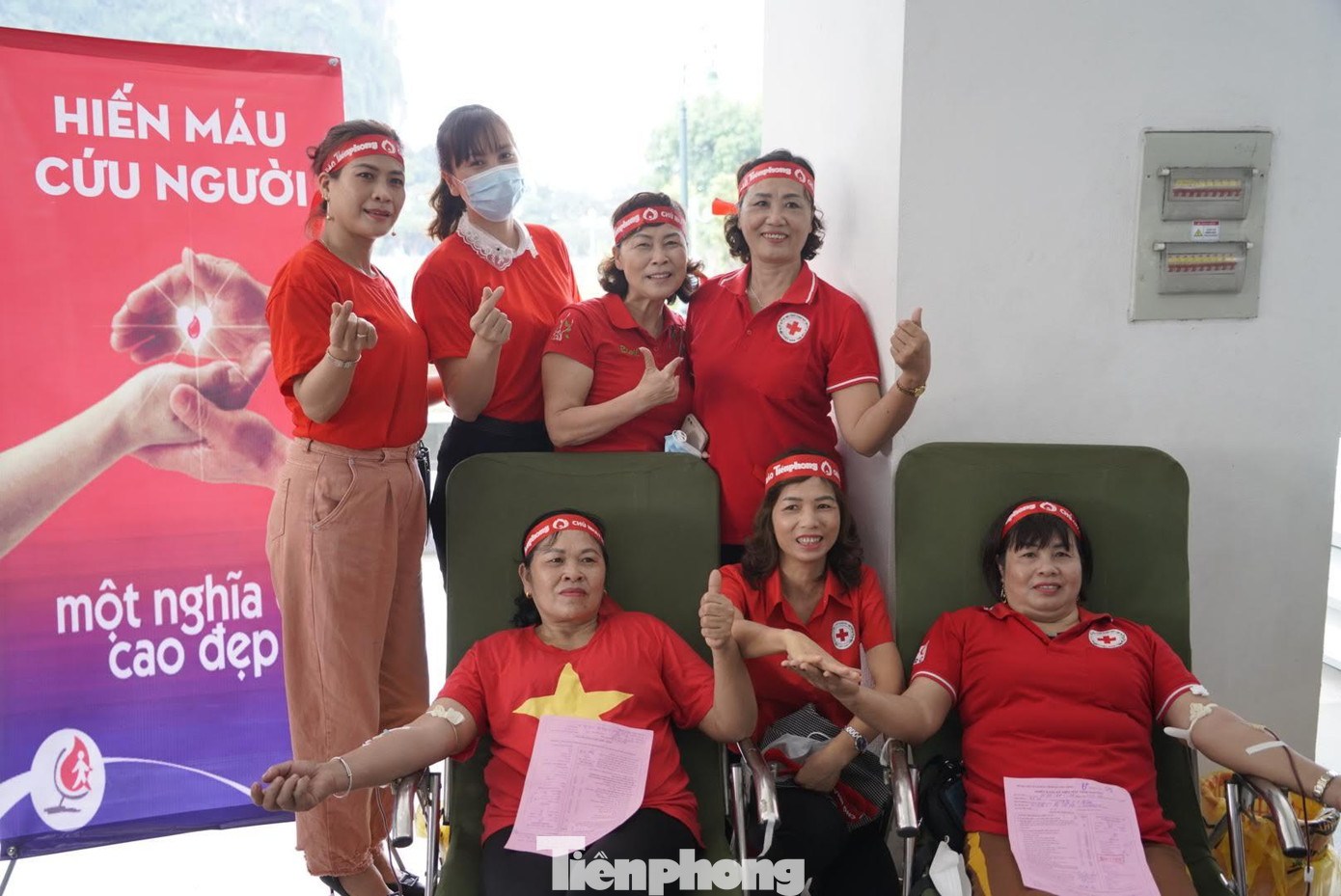 Cô Bùi Thị Nguyệt (53 tuổi, người mặc áo cờ đỏ sao vàng) lần đầu tiên đi hiến máu sau khi tìm hiểu kỹ chương trình Chủ nhật Đỏ do Báo Tiền Phong tổ chức. Trong ảnh: Các thành viên CLB nhóm máu hiếm động viên, cổ vũ cỗ cô Nguyệt.