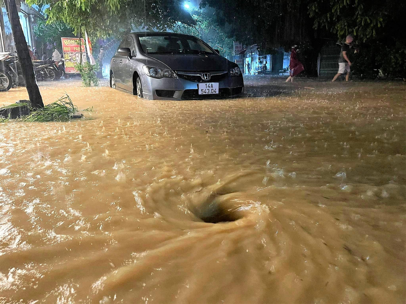 Nước ngập sâu xuất hiện nhiều xoáy nước trên đường rất nguy hiểm.