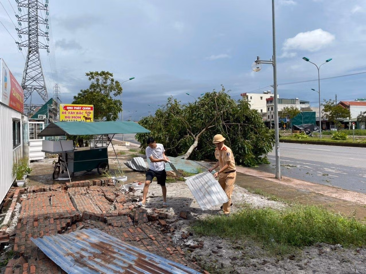 Chiến sỹ CSGT giúp người dân dọn dẹp hàng quán sau bão.