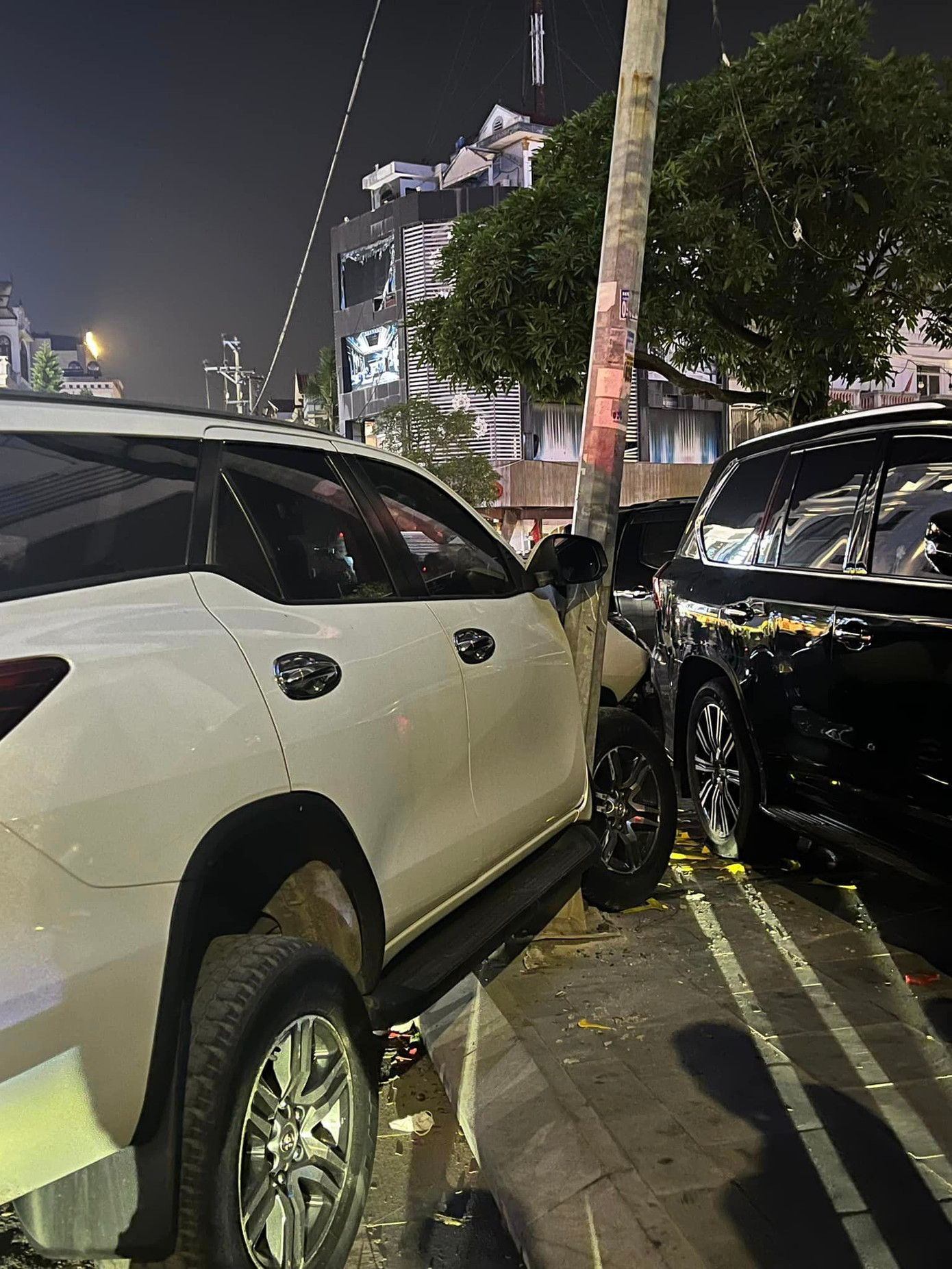 Chiếc xe con BKS 14A-365.xx đang đỗ ven đường cũng bị húc bay lên vỉa hè.