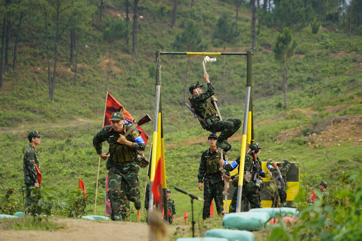 Các chiến sĩ đu dây để trèo qua xà một cách nhanh nhất có thể.