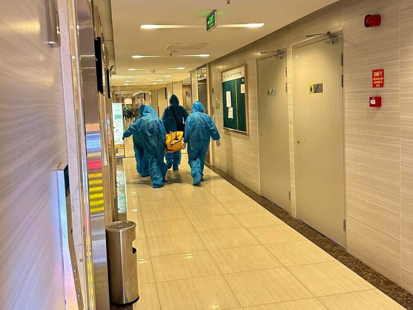 Lực lượng chức năng di dời thi thể ra khỏi căn hộ.