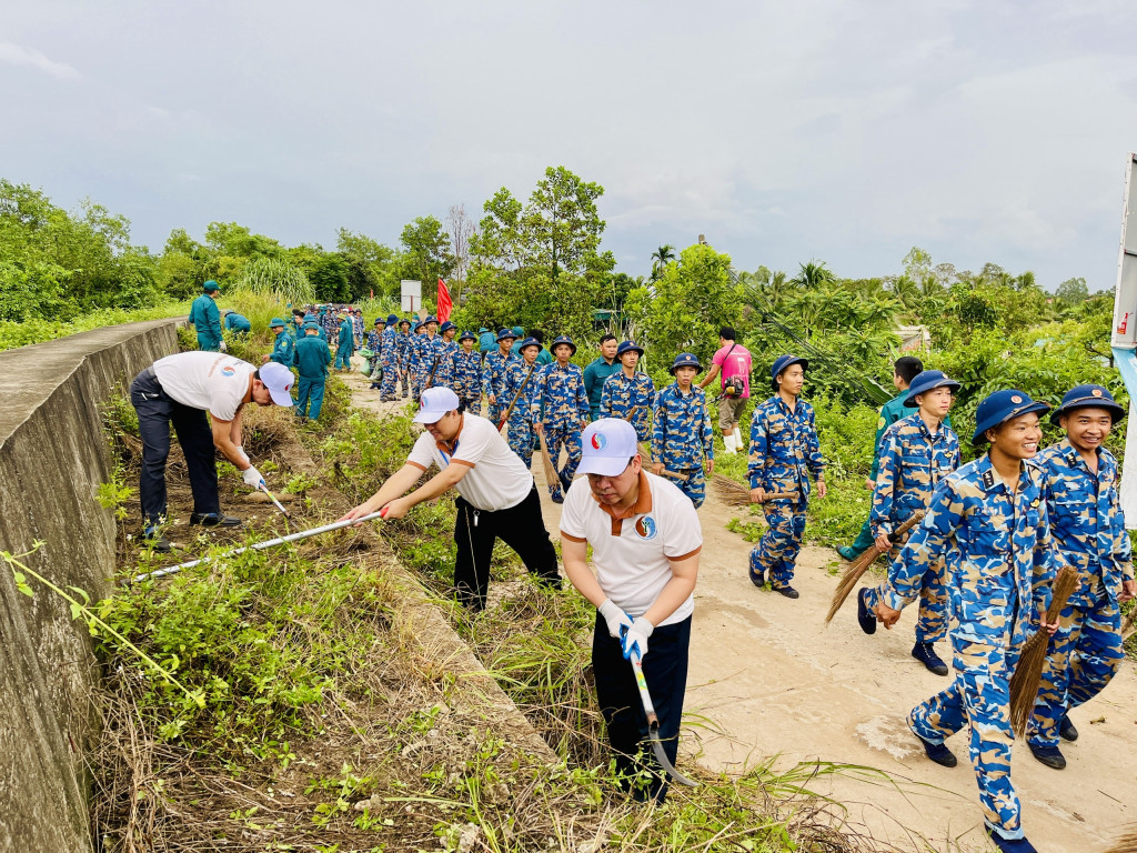 Các đại biểu cùng các lực lượng tổng vệ sinh khu vực đê Hà Nam. Ảnh QMG