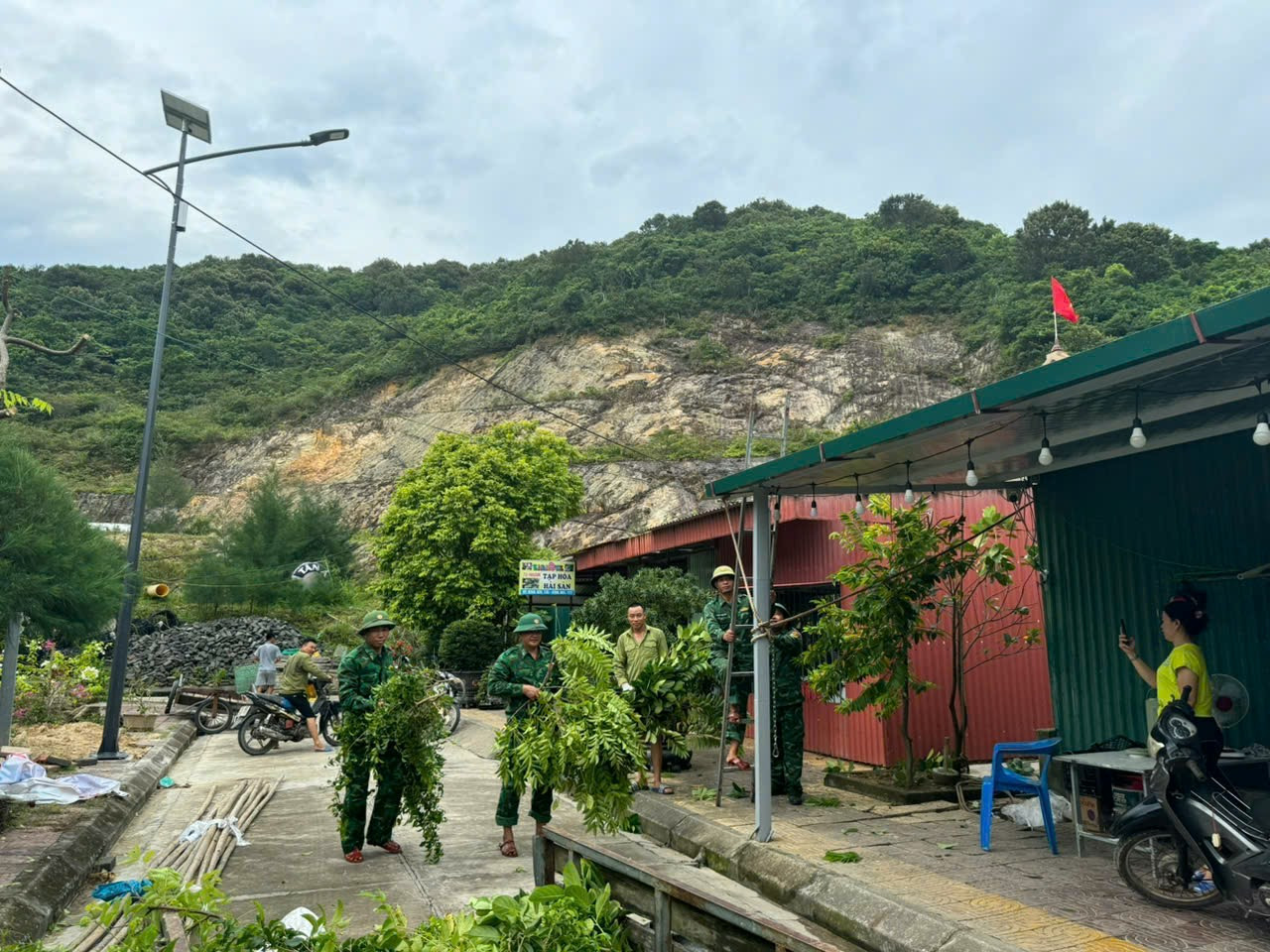 Bộ đội biên phòng đảo Trần giúp người dân cắt tỉa cây xanh.