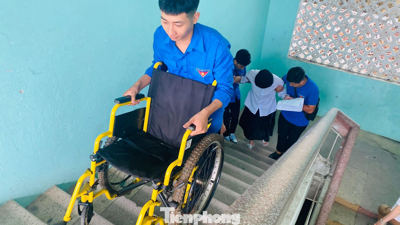 Để kịp giờ thi, các bạn tình nguyện viên đã thay nhau bê cả xe lăn lên cầu thang vào tận phòng thi cho thí sinh bị đau chân.