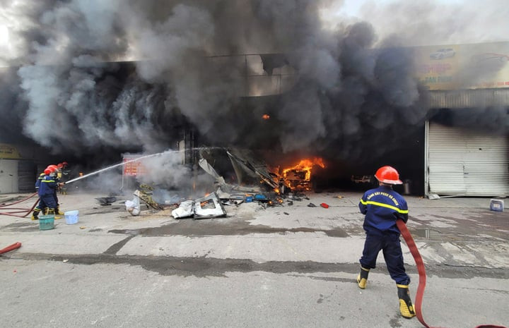 Lực lượng cứu hỏa dùng vòi rồng dập lửa.