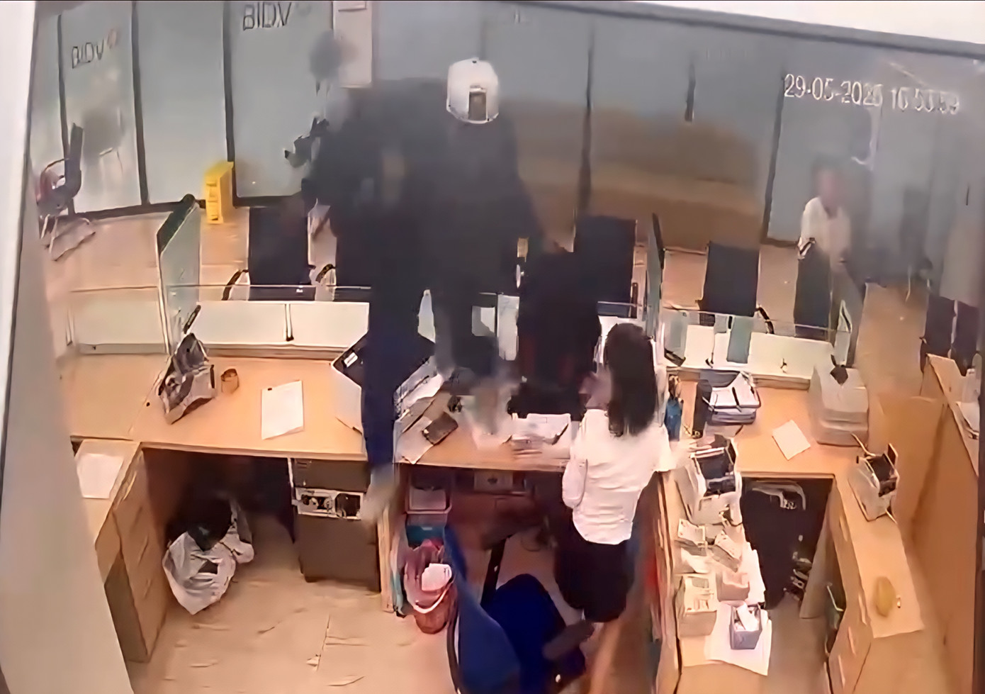 Đối tượng trèo qua vách ngăn kính, lấy đi một số tiền rồi nhanh chóng rời khỏi hiện trường.