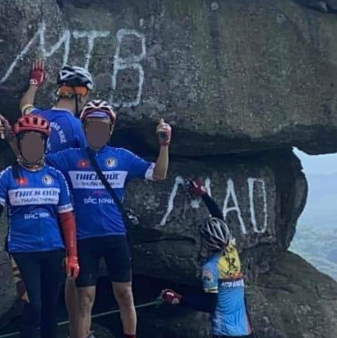 Nhóm du khách dùng sơn viết, vẽ lên núi Đá Chồng. Nhóm du khách dùng sơn viết, vẽ lên núi Đá Chồng.