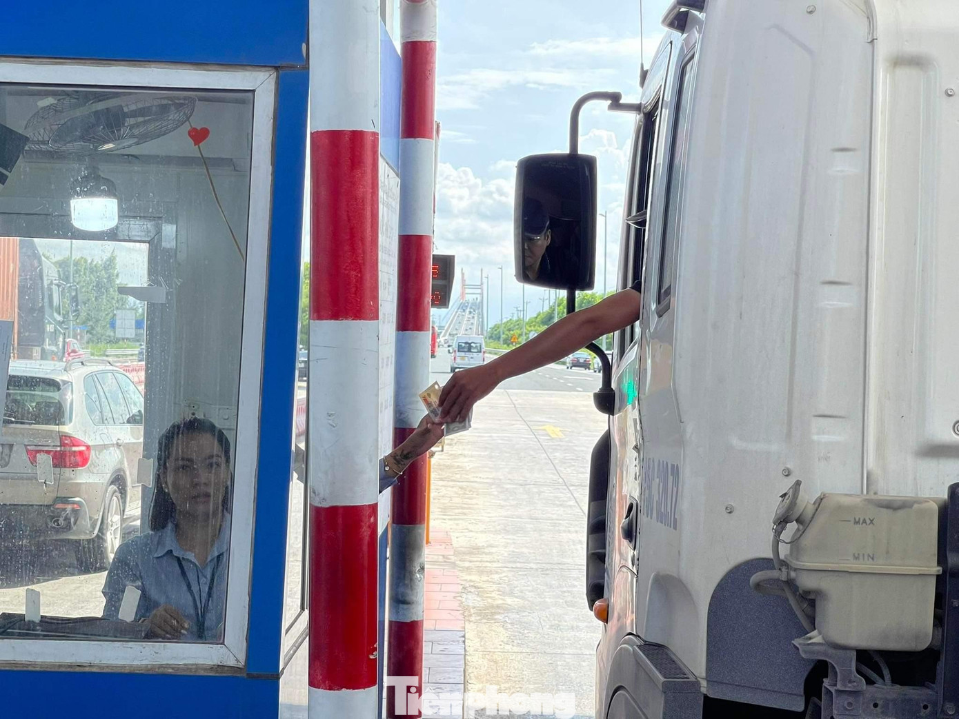 Trước giờ 'G' vẫn còn nhiều phương tiện lưu thông qua trạm thu phí cầu Bạch Đằng bằng cách trả tiền mặt.