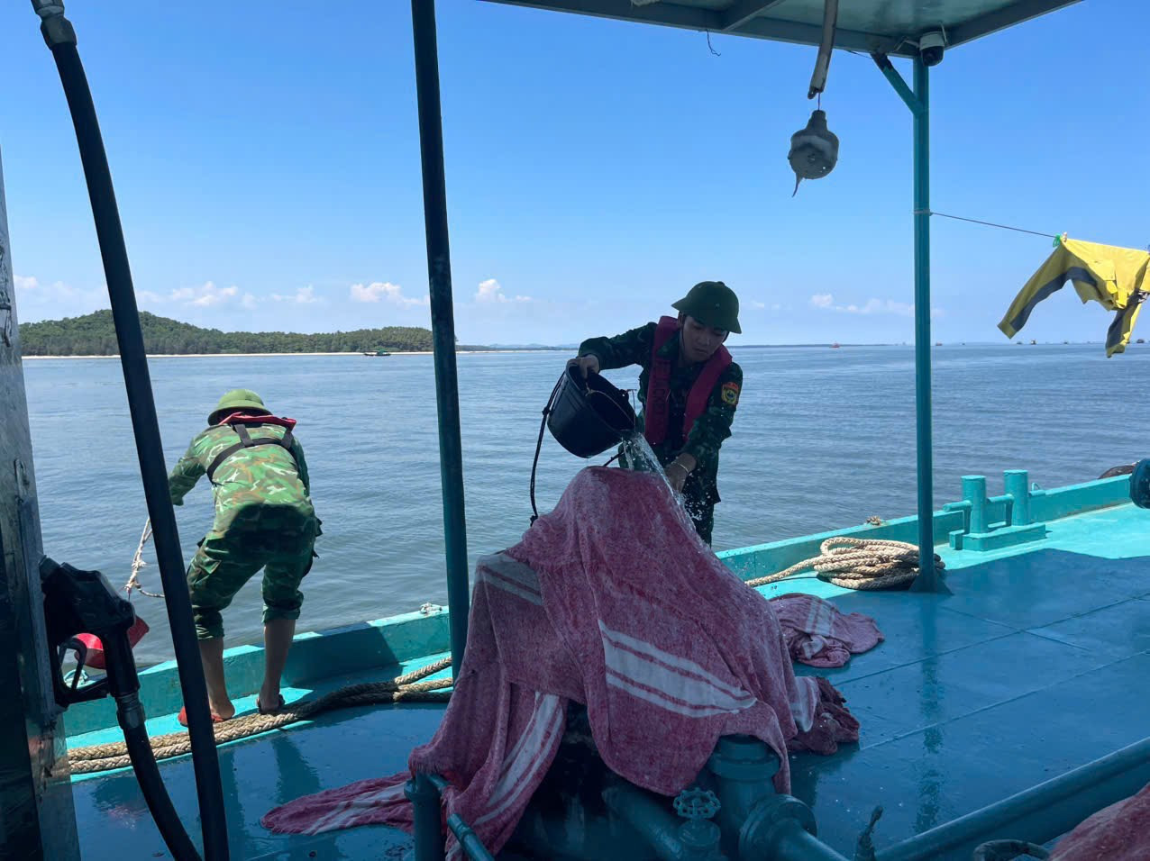 Lực lượng chức năng dùng chăn ướt để dập lửa trên tàu bán xăng dầu.