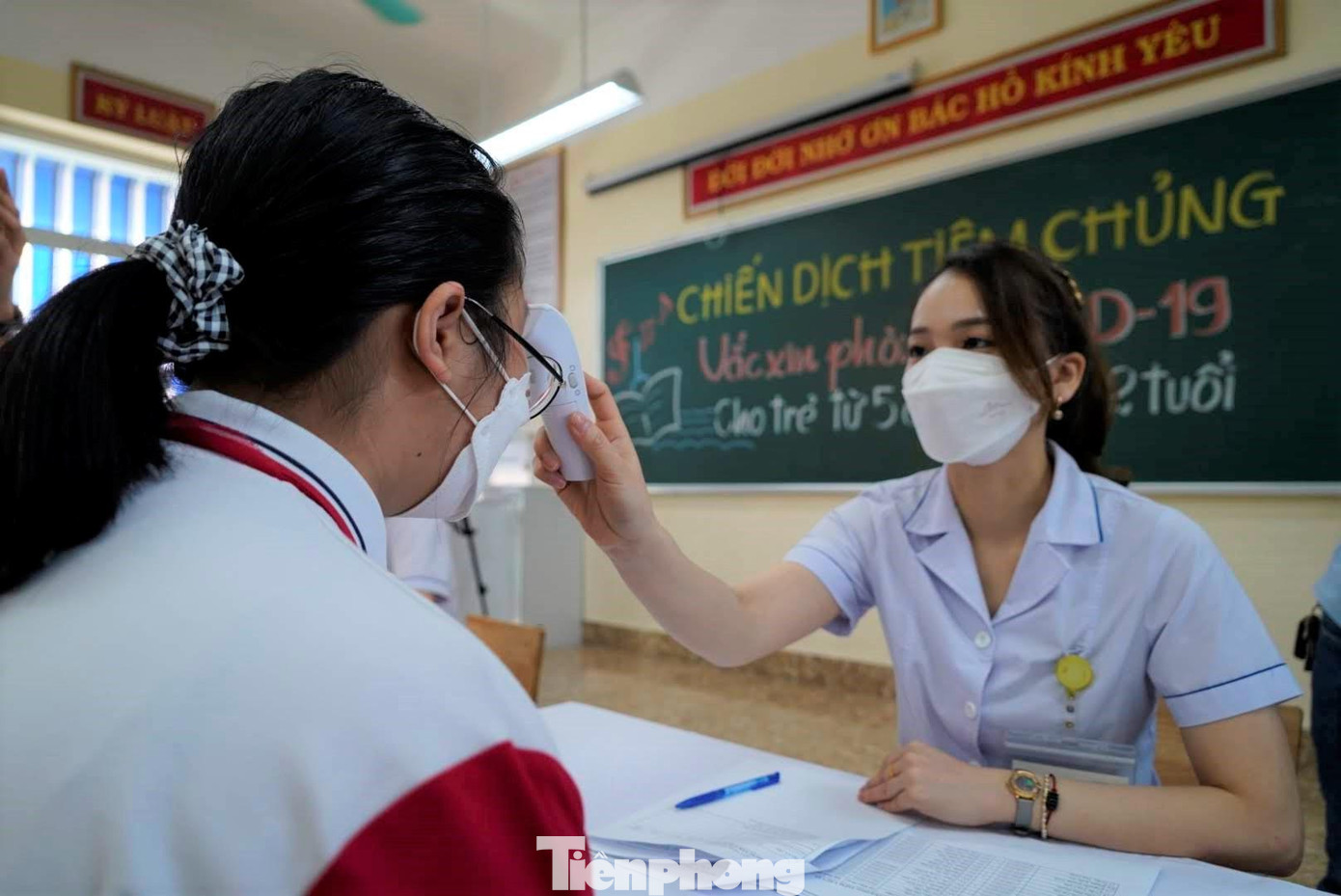 Nhân viên y tế đo nhiệt độ trước khi khai báo thông tin.