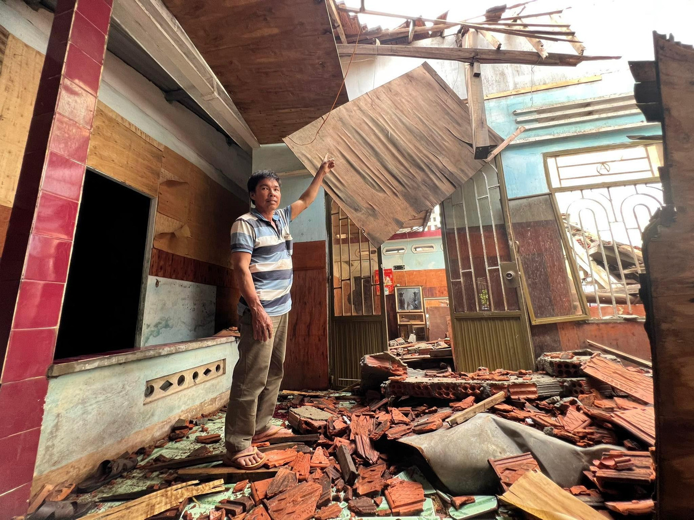 Gió bão cuốn bay bức tường nhà bên cạnh gây sụp đổ mái nhà của gia đình anh Kiều Hà (thôn Đông Lỗ, xã Bình Thuận, huyện Bình Sơn).