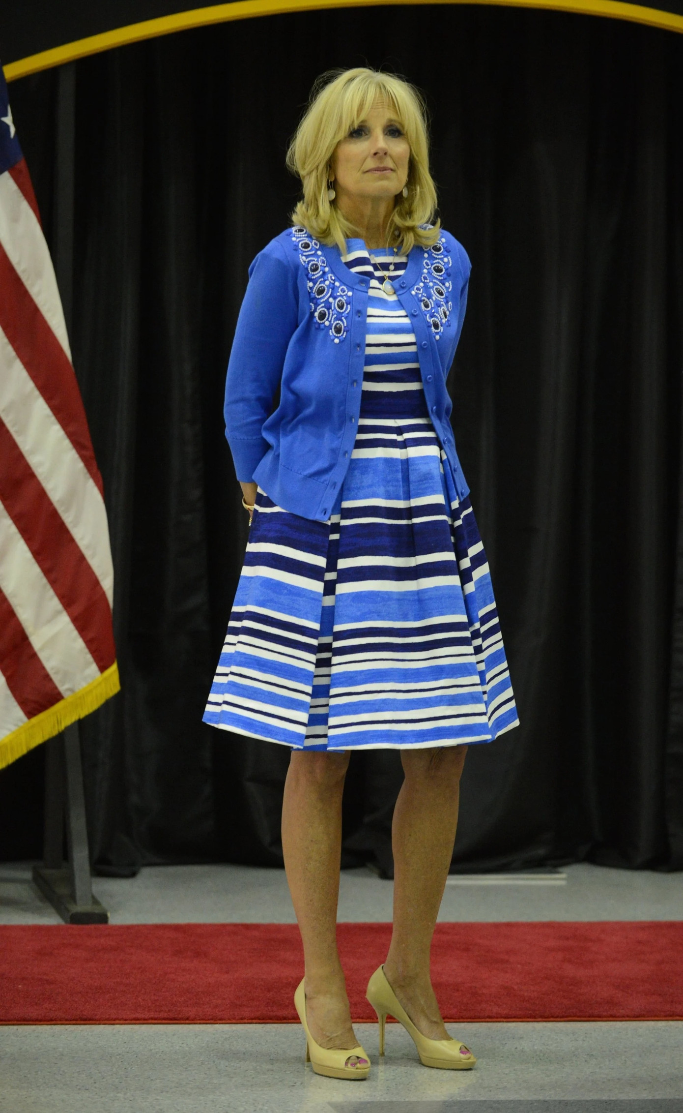 Trong chuyến thăm Căn cứ Quân đội Mỹ Fort Campbell năm 2014, Jill Biden phối trang phục màu xanh lam (váy mido kẻ sọc ngang và áo khoác len đan với đường viền cổ áo đính đá quý) với giày cao gót màu vàng. Ảnh: WireImage. Trong chuyến thăm Căn cứ Quân đội Mỹ Fort Campbell năm 2014, Jill Biden phối trang phục màu xanh lam (váy mido kẻ sọc ngang và áo khoác len đan với đường viền cổ áo đính đá quý) với giày cao gót màu vàng. Ảnh: WireImage.