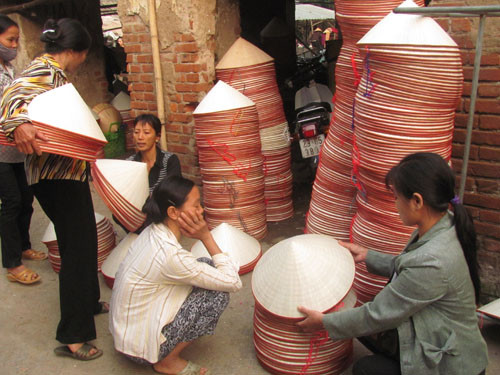 Chưa tới 8 giờ nhưng hoạt động mua bán nón đã gần xong hết. Các lái buôn đang thu mua những chiếc nón cuối của phiên chợ hôm nay.