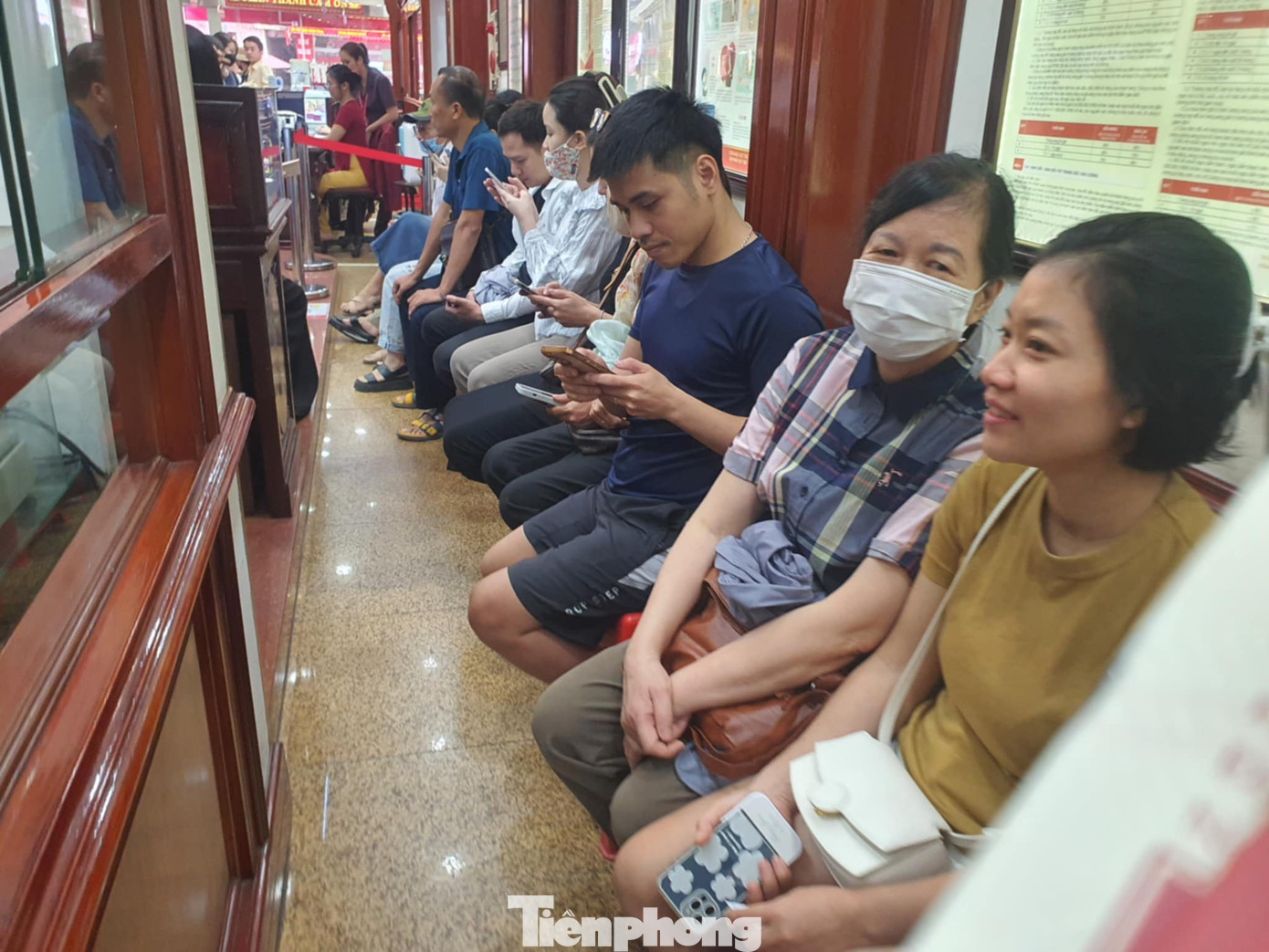 Người dân xếp hàng ngồi chờ mua vàng sáng 12/11 tại cửa hàng vàng trên phố Trần Nhân Tông - Hà Nội.