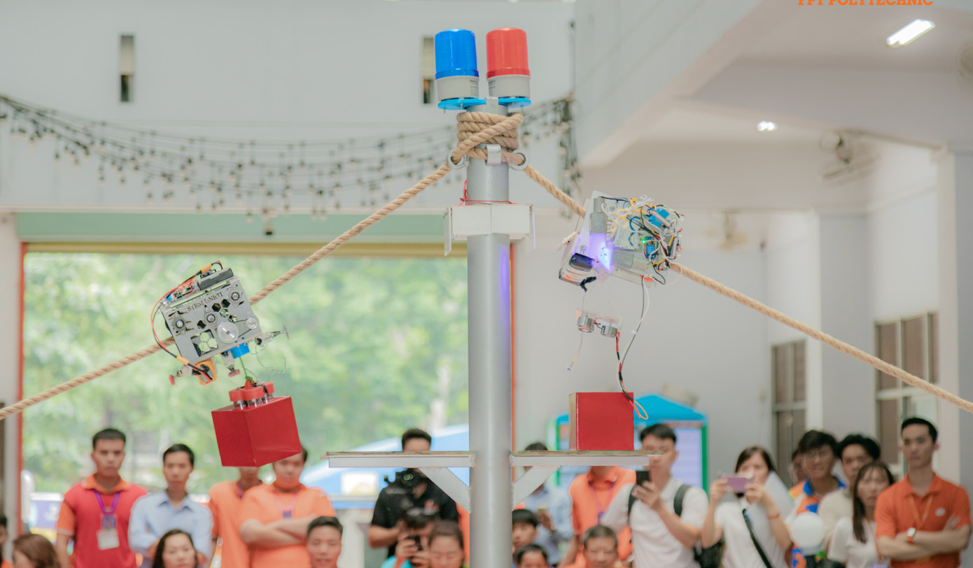 Hai robot leo dây đang khuân vật nặng đến từ hai đội thi đang tiến về vạch đích trên cao