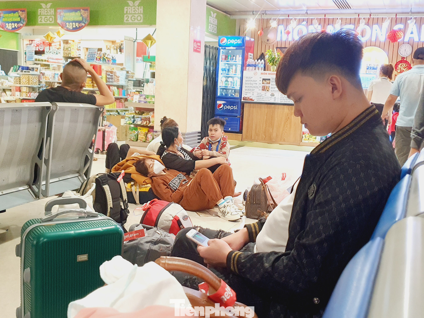 Nhiều người không có ghế ngồi phải ngồi bệt hoặc nằm chợp mắt trên sàn sảnh chờ