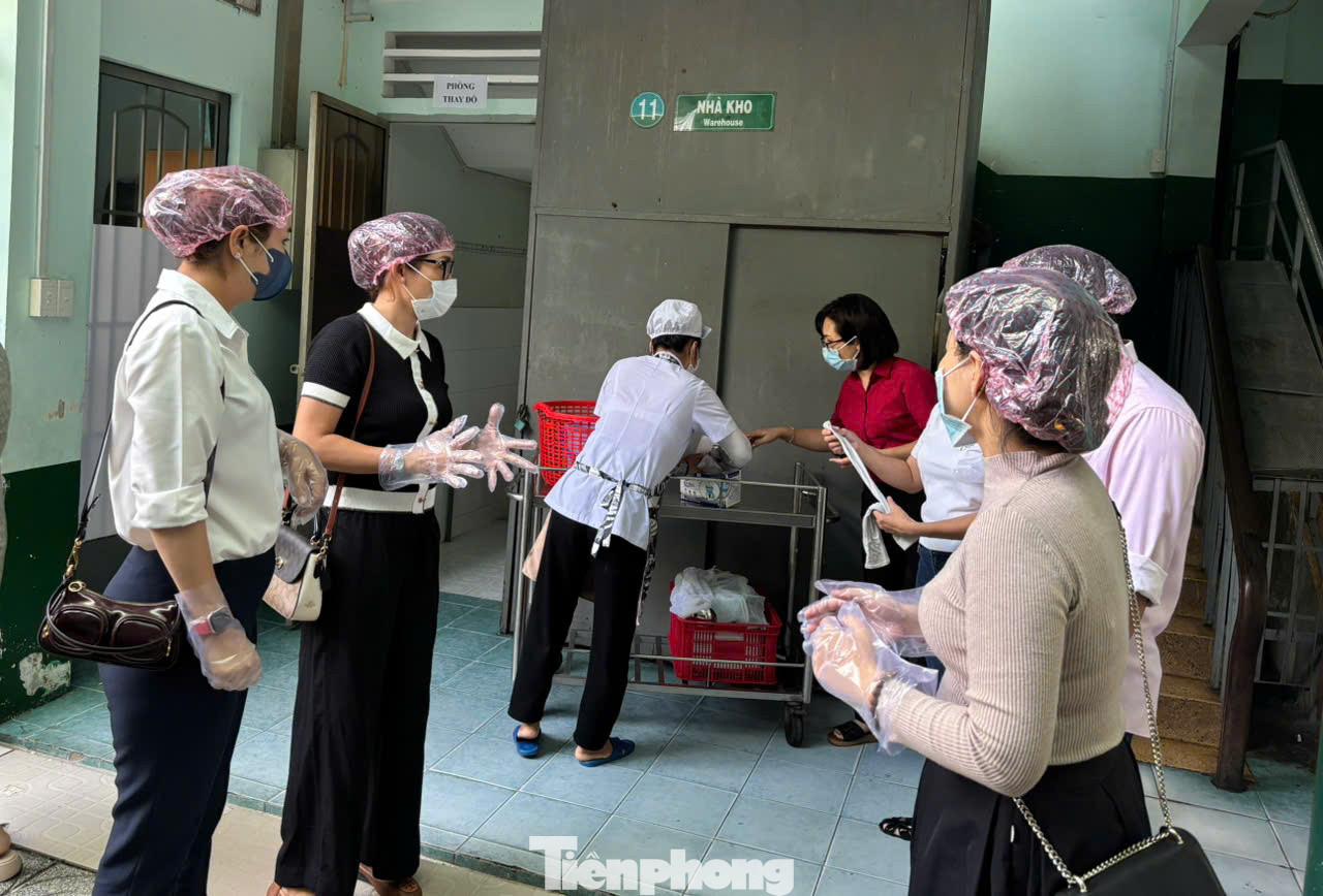 Trước khi vào bếp ăn, phụ huynh được yêu cầu trang bị đồ bảo hộ