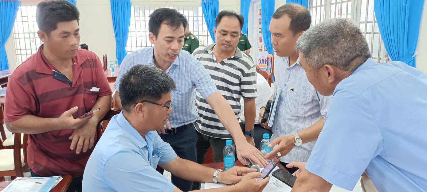 Bà con ngư dân, lực lượng chức năng tìm hiểu thông tin về công tác chống khai thác hải sản IUU.