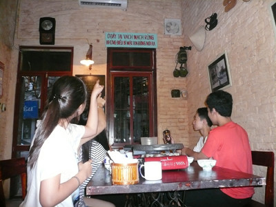 Các bạn trẻ thú vị với câu khẩu hiệu treo trong quán