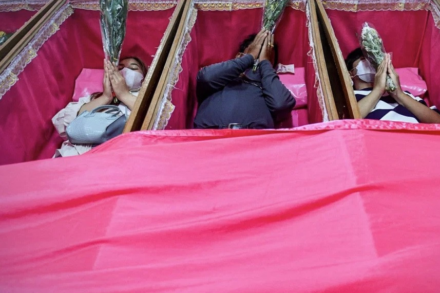 Nằm trong quan tài mở là cách mà nhiều người tin rằng có thể giúp xua vận đen. (Ảnh: ANN)