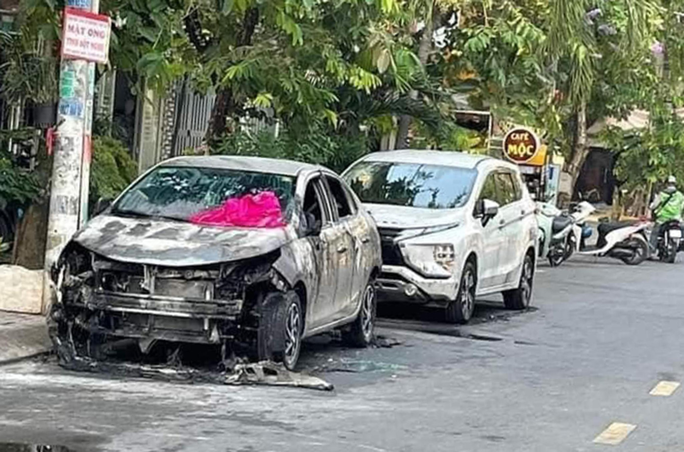 Hai chiếc xe ô tô đậu sát nhau bị đốt cháy.