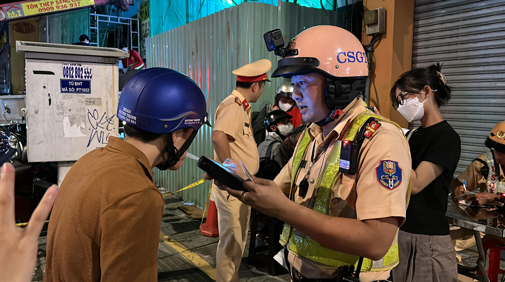 CSGT kiểm tra nồng độ cồn của chị T. sau khi phát hiện chị này điều khiển xe máy có biểu hiện không tỉnh táo. Ảnh: NGUYỄN YÊN